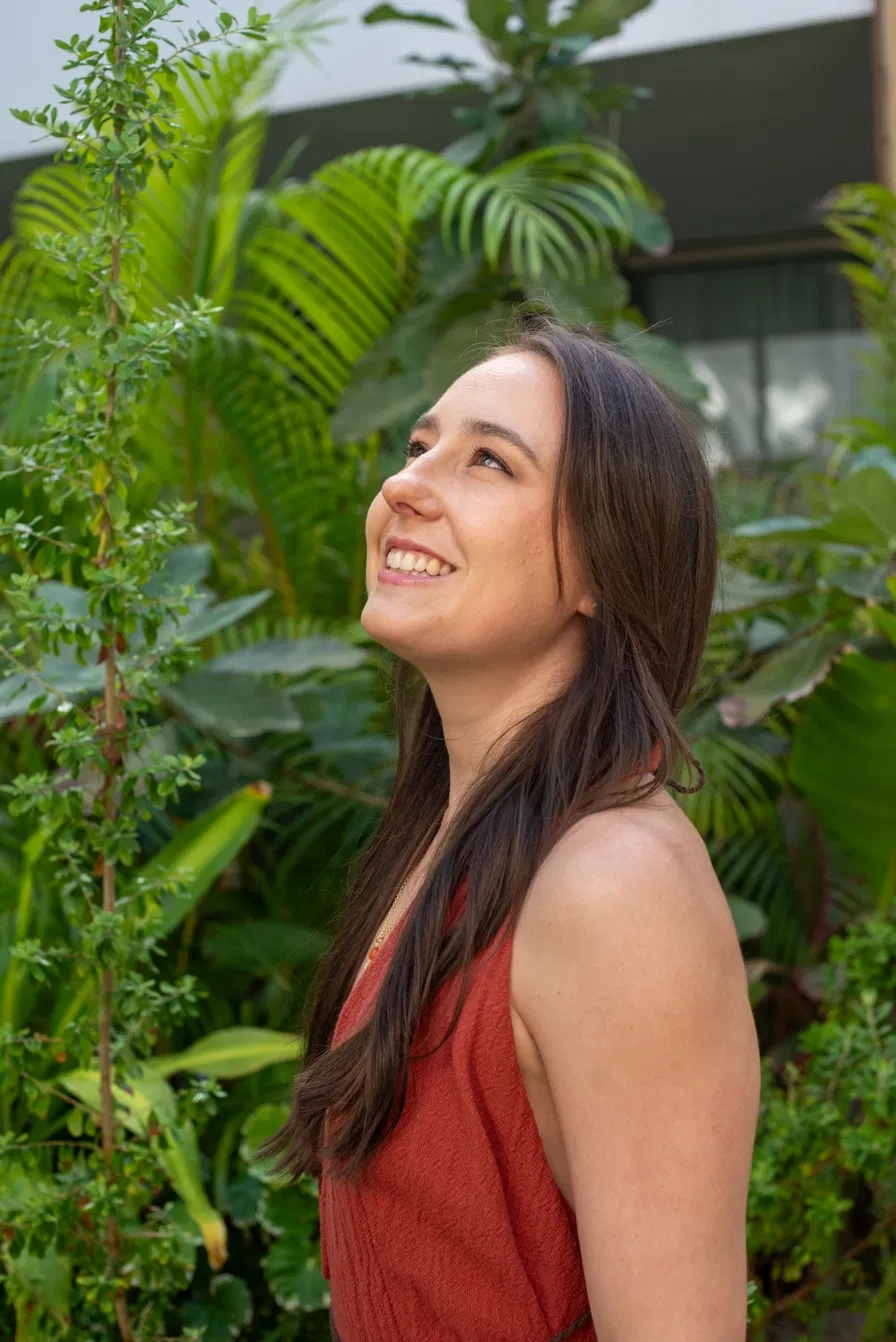 Gabriela smiling among tropical foliage